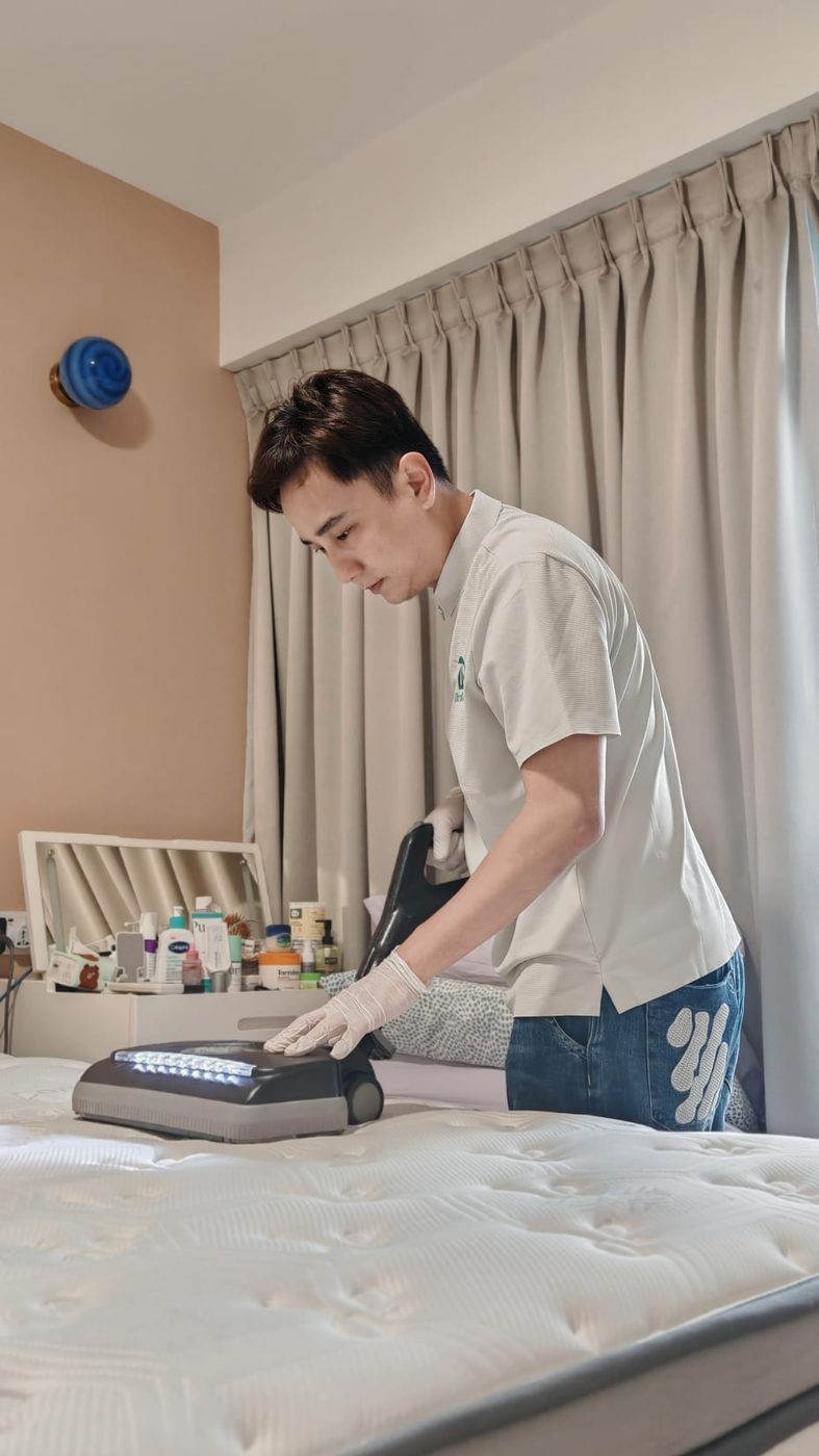 UltraRevive technician deep-cleaning a mattress in a Singapore bedroom