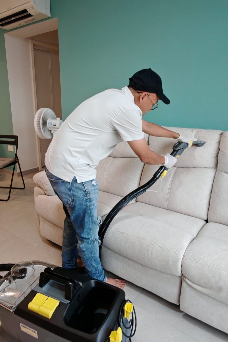 UltraRevive technician steam-cleaning a white fabric sofa in Singapore